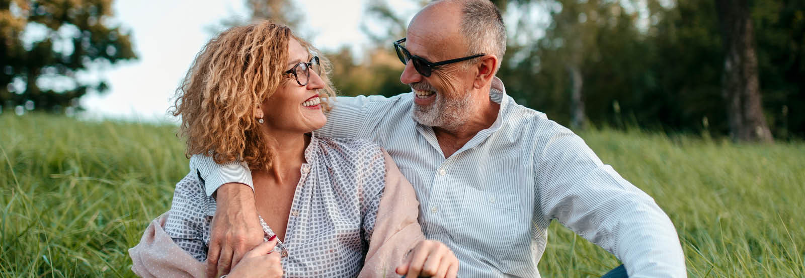 middle age man and woman with glasses  smiling at each other outdoors 1600x552.jpg
