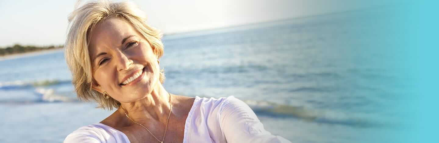 older woman smiling on the beach.jpg