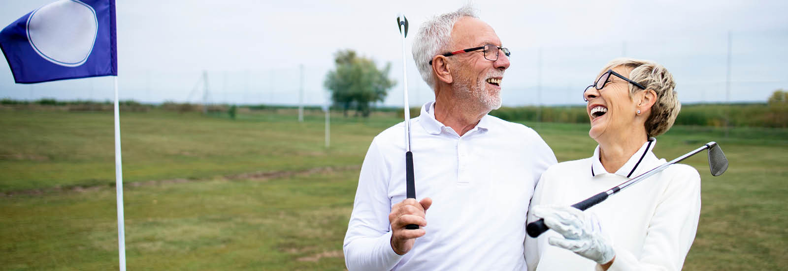 retired couple playing golf smiling